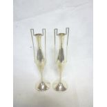 A pair of George V silver tapered spill vases with angular handles on circular bases,