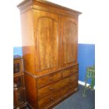 A Victorian figured mahogany linen press with sliding trays enclosed by two arched panelled doors