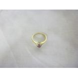A 9ct gold dress ring set a central ruby surrounded by diamond chips
