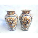 A pair of 19th Century Japanese Imari pottery tapered vases with painted blue and red floral