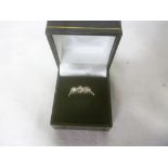 An 18ct gold engagement ring set three diamonds flanked by a diamond chips