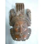 A Chinese carved hardwood mask figure with raised dragon decoration