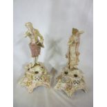 A pair of German porcelain figures of a classical male and female on floral decorated tapered bases