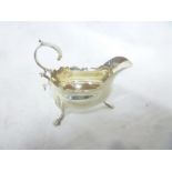 A George III silver classical shaped sauce boat with scroll handle on three hoof feet,
