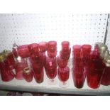 A selection of cranberry tinted glassware including beakers, stemmed drinking glasses,