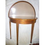 A polished mahogany semi-circular turnover top card table on square tapered legs with capped feet