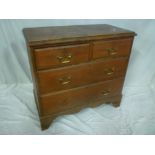 A small stained pine chest of two short and two long drawers on bracket feet