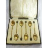 A set of six silver gilt and enamelled coffee spoons with bean terminals,