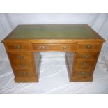 A late Victorian oak rectangular pedestal desk with three drawers in the frieze and six pedestal