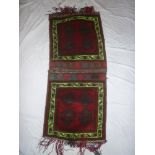 An Eastern hand woven wool saddle bag with geometric decoration on red ground