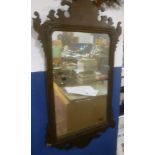 An early 19th Century rectangular wall mirror in ornate mahogany scroll frame