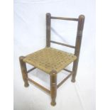 A 1920's/30's child's beechwood occasional chair with stringwork seat
