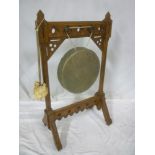 A late 19th Century Pugin-style carved oak gong stand with inset painted red and blue panels on