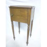 A Victorian mahogany pot cupboard enclosed by a single panelled door on turned tapered legs