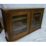 A late Victorian mahogany bookcase with shelves enclosed by two glazed doors on turned feet