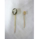 An 18ct gold stick pin mounted an oval cameo and a 9ct gold stick pin with shield mount in-set with
