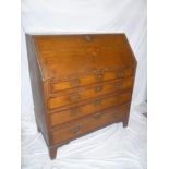 A George III oak and mahogany cross banded bureau with fitted interior enclosed by a fall front