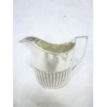 A late Victorian silver oval cream jug with gadrooned decoration and angular handle,