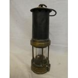 An old brass & steel miner's lamp with swing handle