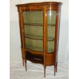 A late Victorian inlaid mahogany serpentine fronted display cabinet with fabric lined shelves
