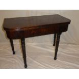 A 19th Century figured mahogany rectangular turn-over top tea table on turned tapered legs