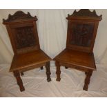 A pair of Continental carved oak hall chairs,