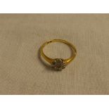 An 18ct gold dress ring with floral mount set diamond chips