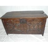 An 18th Century carved oak rectangular coffer with decorated front and hinged lid on block feet