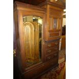 A Victorian walnut combination wardrobe with hanging compartment enclosed by an arched mirror
