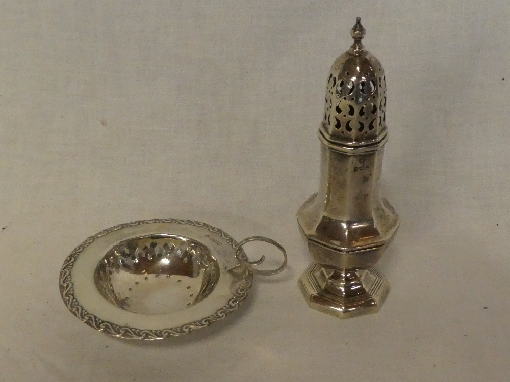 An Edward VII silver circular strainer with raised decoration and loop handle,