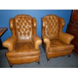 A pair of good quality wing easy chairs upholstered in brown buttoned leather on cabriole feet