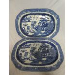 A pair of early 19th Century pottery oval meat platters with blue & white Willow pattern decoration