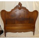 A French carved walnut double bed with arched panelled ends