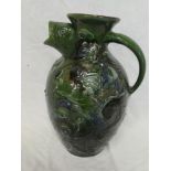 A Brannam Barnstaple pottery tapered fish jug with fish head spout and scaled decoration on green