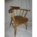 An old elm and beech Captain's style armchair with spindle back and shaped seat on turned legs