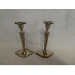 A pair of George V silver candlesticks with tapered stems and oval bases, London marks 1910,