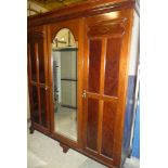 A late Victorian mahogany triple wardrobe with sliding trays,