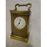 A good quality carriage clock with circular enamelled dial in brass traditional glazed case