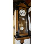 A Vienna style wall clock with enamelled circular dial in ebonised and polished walnut glazed case