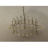 A George V silver six-section arched toast rack with loop handle on claw and ball feet,