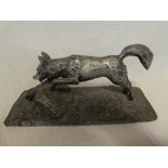 An unusual cold cast white metal figure of a running fox on rectangular base, 18" long,