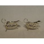 A pair of late Victorian silver classical shaped sauce boats with raised decoration and scroll