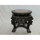 A Chinese carved rosewood circular plant stand with in-set pink veined marble centre,
