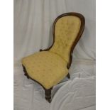 A Victorian mahogany ladies easy chair upholstered in button fabric on turned legs