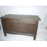 An 18th Century oak rectangular coffer with triple panelled front and hinged lid on block feet