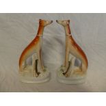 A pair of Victorian Staffordshire pottery figures of seated greyhounds with hare quarry,