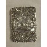 An ornate Victorian silver rectangular visiting card case decorated in relief with a country house
