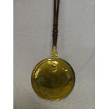 An early 19th Century brass circular warming pan with turned wood handle
