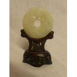 A Chinese jade circular panel decorated in relief with a dragon,