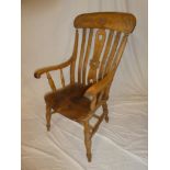 A beech and elm kitchen style carver armchair with lath back and shaped seat on turned tapered legs